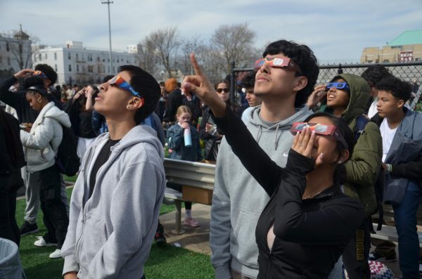 Students Pedro Corranza, Matt Hernandez, and Pamela Rodriguez gaze up into the sky, hoping to catch sight of the rare Eclipse phenomenon with their special protective glasses.
