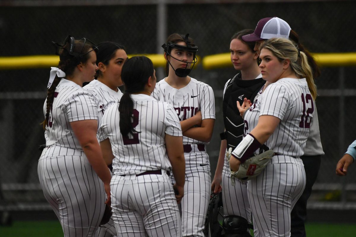 The girls softball team huddles together as they plan their next move.